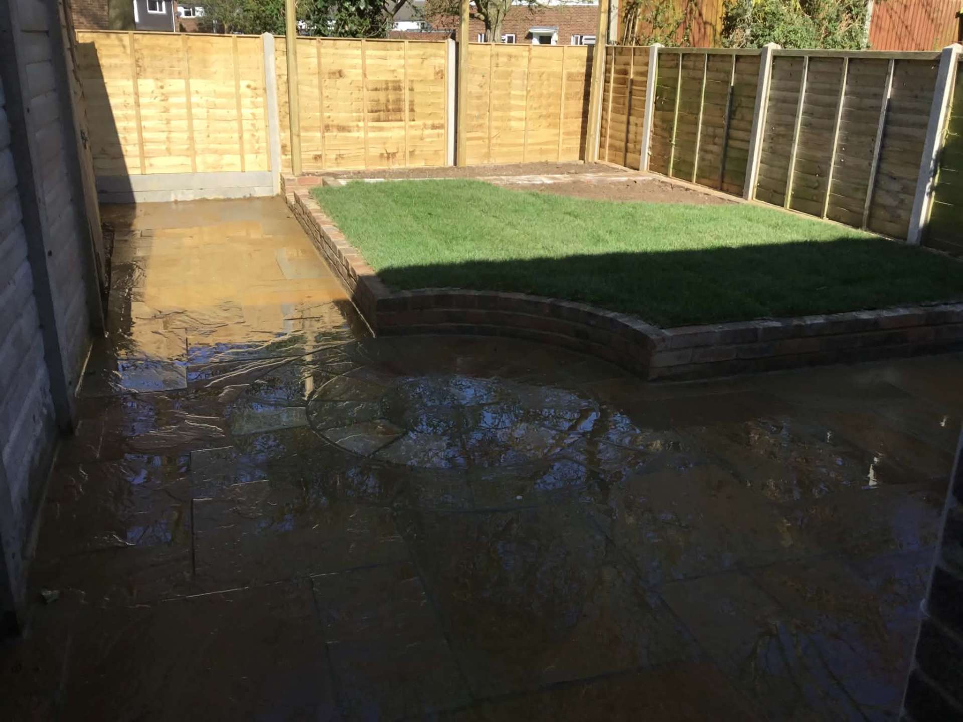 Slate patio with circle detail and brick retaining wall