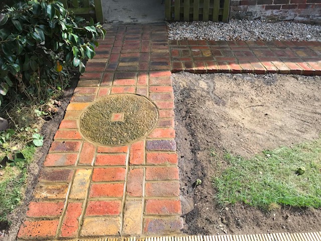 Reclaimed brick path with circular millstone detail