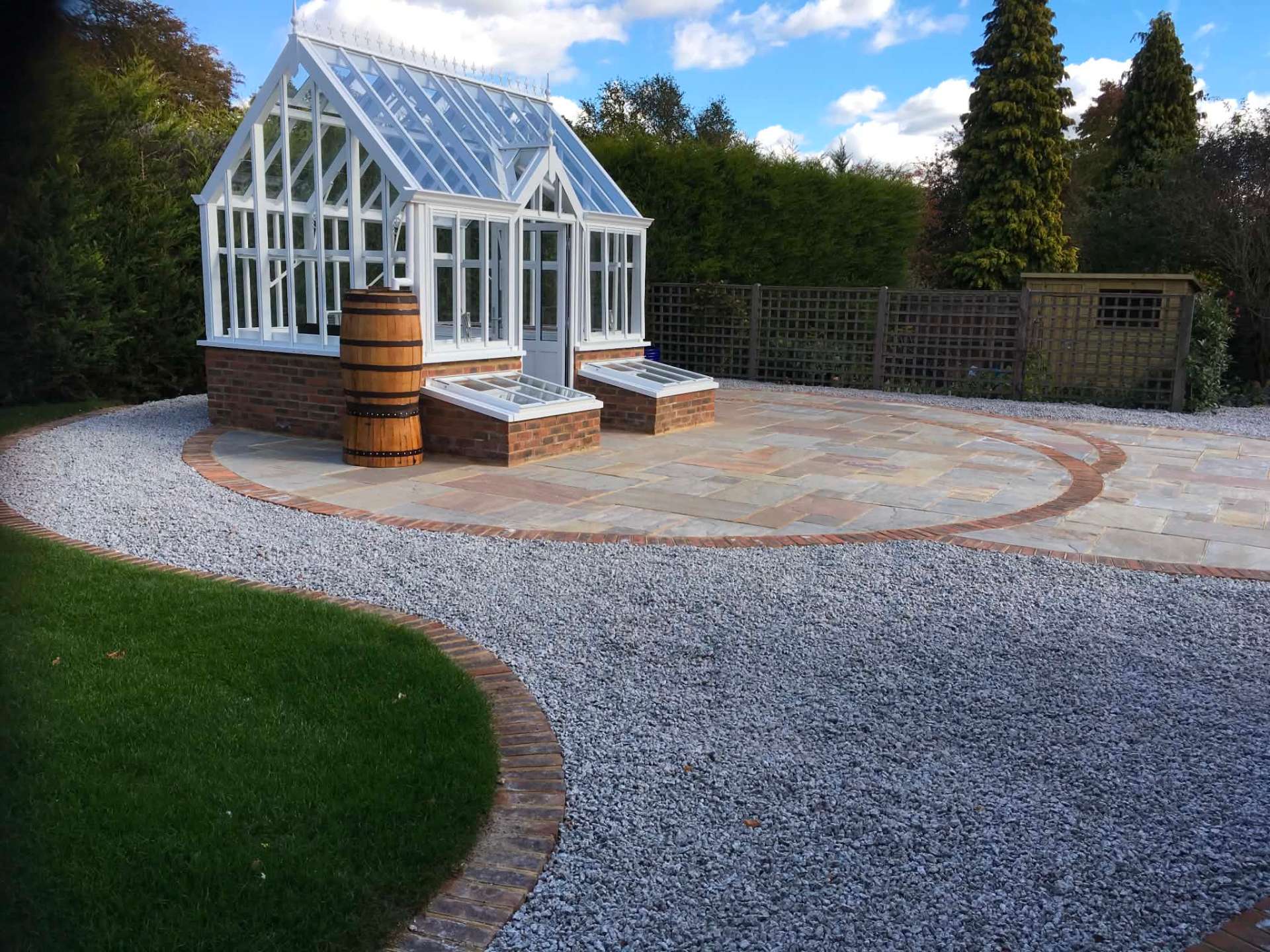 Victorian glasshouse on sandstone circle with gravel surround