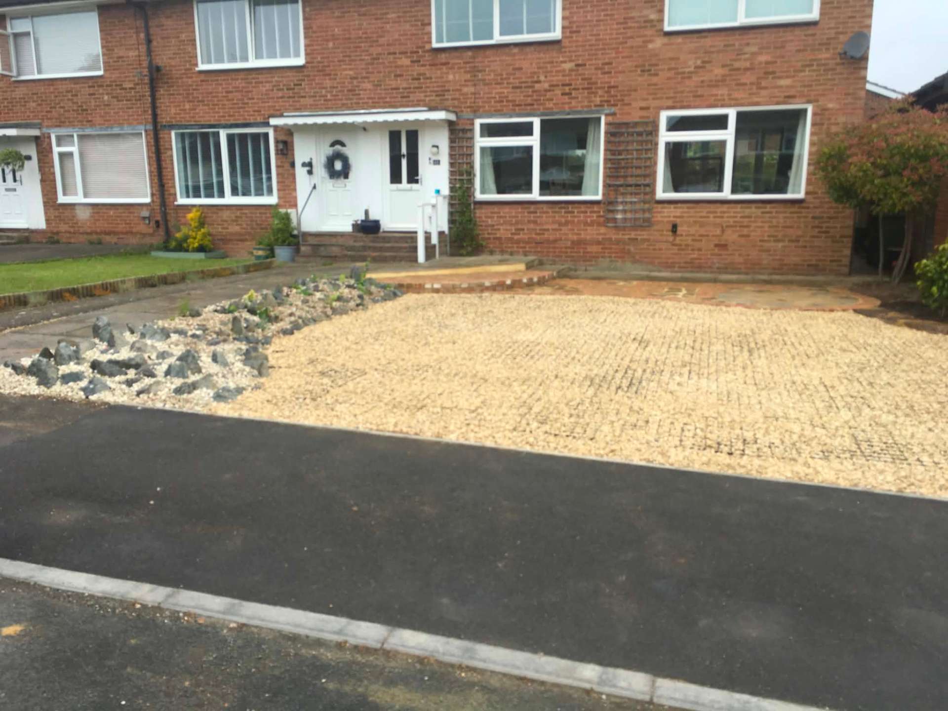 Gravel grid driveway with rockery border and brick edging