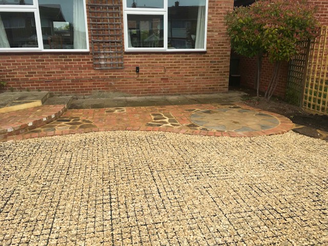 Circular crazy-paving feature meeting gravel driveway