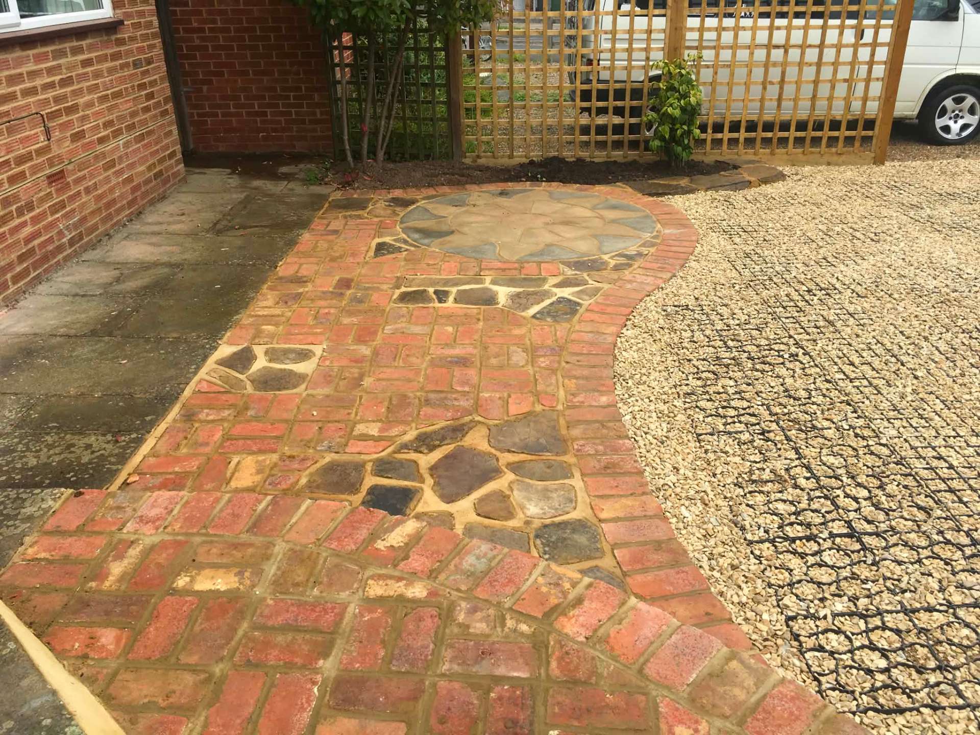 Brick and crazy-paving path with decorative sun-pattern circle