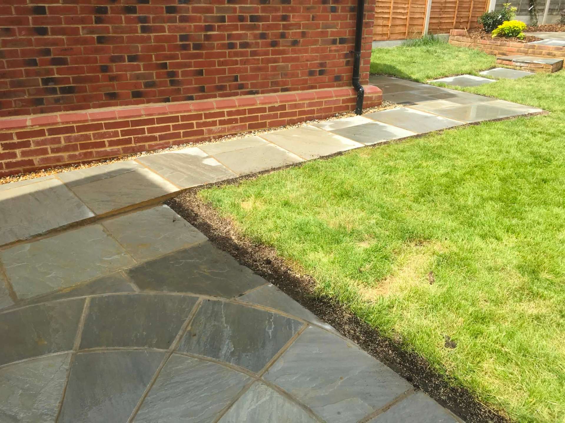 Sandstone patio with circle, stepping stones and fresh lawn